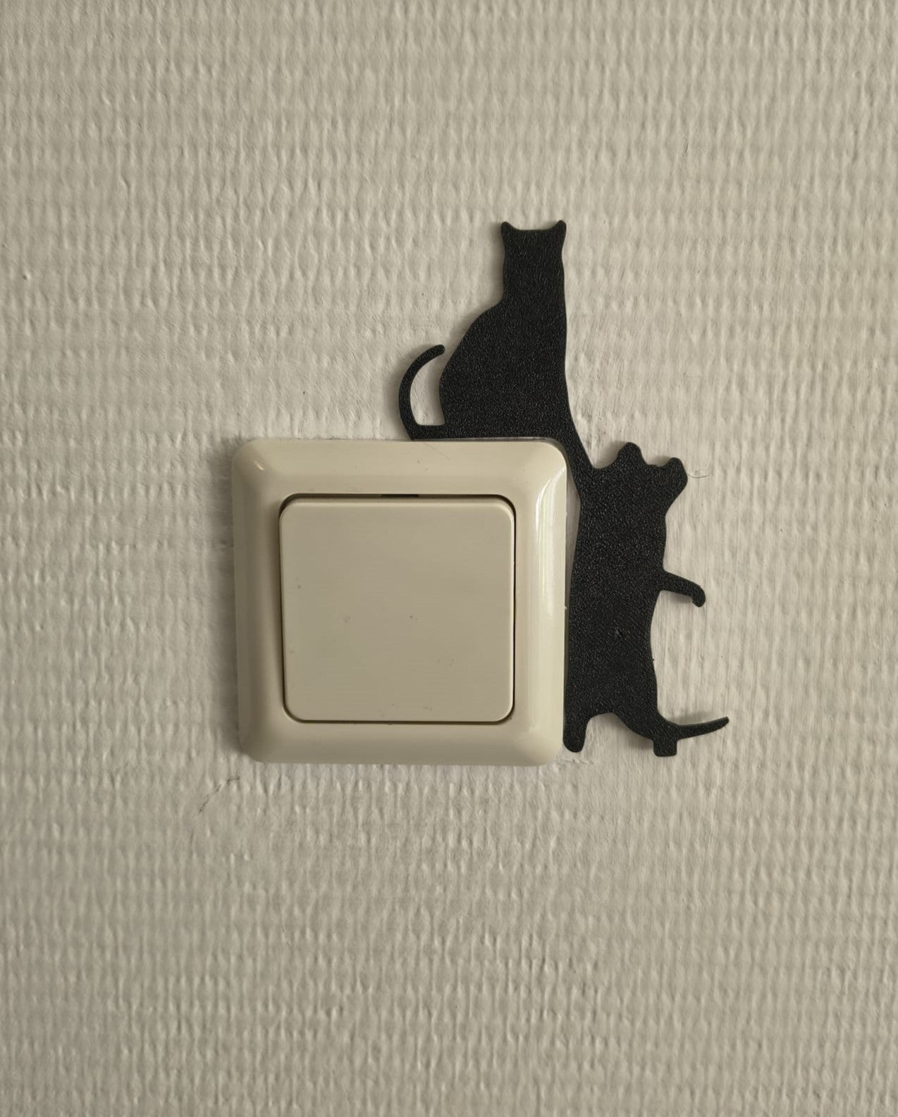 Katten lichtschakelaar decoratie van twee katten die op de lichtschakelaar of stopcontact klimmen. Te monteren zonder boren